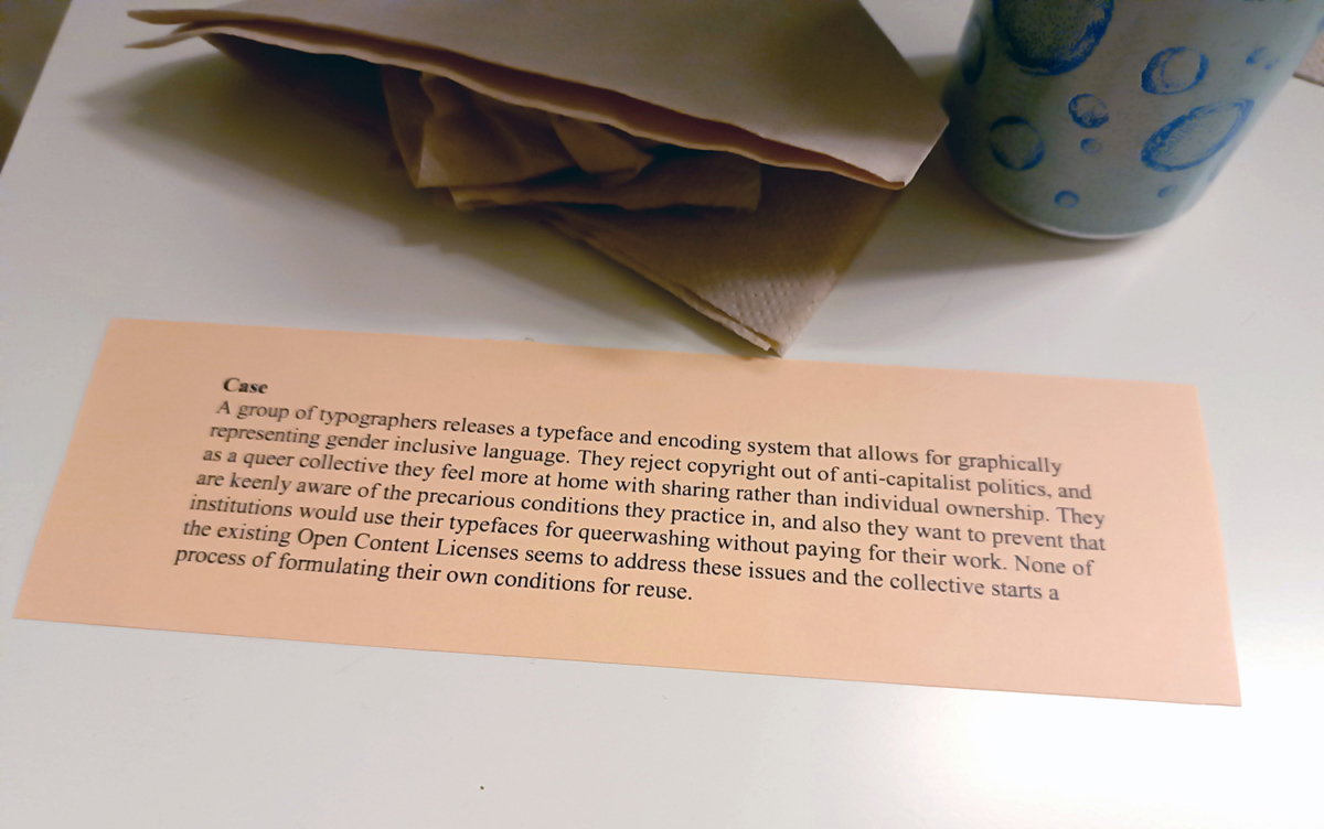 A short text paragraph printed on a coloured paper slip on a table that had been distributed alongside many other cases for a research presentation