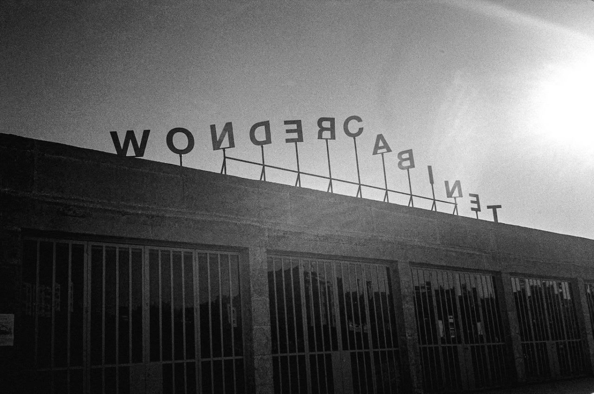 Stylized photo of the the steel letters spelling "Wonder Cabinet" on top of the building of the space.